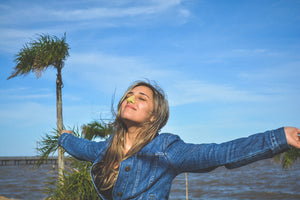 Women reaching out looking up with safe sunscreen on nose